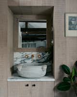 In the bathroom, a small antique marble basin is nestled within a limed oak alcove.