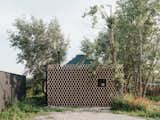 Exterior, Cabin Building Type, Wood Siding Material, and Small Home Building Type When not in use, a lattice panel covers the facade, closing off and protecting the cabin when the couple is back in the city.  Photo 3 of 13 in This Serene Cabin in Slovakia Takes the Shape of a Yurt