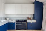 The multi-hued cabinets complement the apartment's cool gray terrazzo worktop.