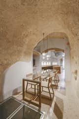 Dining Room, Pendant Lighting, Chair, Terrazzo Floor, and Table This minimalism highlights the curves and textures of the cave walls and ceilings.  Photo 14 of 16 in Stay in This Extraordinary Cave Hotel in Southern Italy
