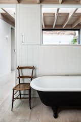 The main bathroom is located off the stairwell. This area has cut-out openings that draw in plenty of light from a courtyard garden sited on the opposite side of the open-tread stairs.