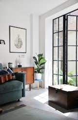 Crittall windows cast playful sun squares along the floors, and deep exposed joists imbue the interiors with a warm golden glow.
