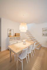 Dining Room, Light Hardwood Floor, Pendant Lighting, Table, Shelves, and Chair The structural walls and original staircase was kept intact.  Photo 3 of 12 in A Revamped Modern Home Is Sprinkled With Old-World Charm