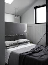 Bedroom, Pendant Lighting, Bed, and Table Lighting The innovative conceptual framework draws in plenty of natural light, and results in a seamless connection between different parts of the house. The wardrobe in the bedroom is hidden behind the bedhead box. 

  Photo 10 of 14 in A Melbourne Home Is Treated to a Striking Barn–Like Extension