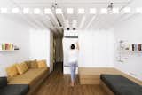 Slim, white, brise soleil-like beams run along the length of the ceiling in the mid-section of the apartment.