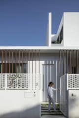 The pattern of the decorative screen for the stairs is repeated on the fence that surrounds the house.