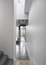 Hallway, Concrete Floor, and Light Hardwood Floor "One of the most interesting features is the glazed floor above the master corridor that allows a flood of light to penetrate into the kitchen zone," says Robertson.

  Photo 6 of 19 in A Historic Melbourne Home Is Respectfully Modernized For a Young Family