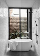 Sliding glass doors next to a freestanding bath provide visual connectivity to the outdoors.