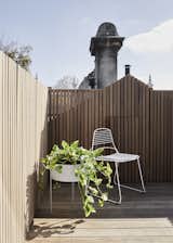 Outdoor, Small Patio, Porch, Deck, Wood Fences, Wall, and Planters Patio, Porch, Deck On the roof terrace is a casual chair and planter, which helps make this space a lovely spot to relax and soak up the Australian sunshine.

  Photo 16 of 19 in A Historic Melbourne Home Is Respectfully Modernized For a Young Family