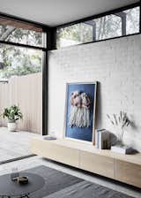 Living Room, Storage, Console Tables, Concrete Floor, Rug Floor, and Coffee Tables Washed oak joinery and textured tiles add warmth to the space, providing a soft contrast to the crisp concrete and brick.  

  Photo 8 of 19 in A Historic Melbourne Home Is Respectfully Modernized For a Young Family