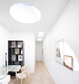 Office, Bookcase, Study Room Type, Library Room Type, Chair, Light Hardwood Floor, and Desk A crisp palette of toned woods and fresh white paint give the indoor and outdoor spaces a light and open feel.

  Photo 6 of 19 in 11 Skylights Brighten a Compact, Narrow Home in Vancouver