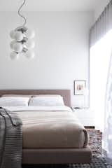 If you need bedroom lighting ideas for the ceiling, check out how this tonal bedroom in Vancouver utilizes a modern pendant light to add visual interest while tying perfectly with the desk lamp.&nbsp; &nbsp;