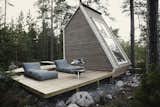 Nido Cabin by Robert Falck exterior with wood deck patio and forest landscape
