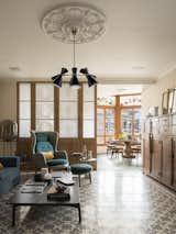 Living Room, Coffee Tables, Cement Tile Floor, Pendant Lighting, and Chair A look at the floor lamp by Pulpo Lighting, coffee table by Cassina, armchair by Mod: Ro, and ottoman by Fritz Hansen.

  Photos from A 1930s Barcelona Apartment Is Revitalized Into an Airy Abode