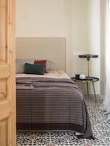 Bedroom, Cement Tile, Table, Bed, and Night Stands Patterned hydraulic tiles on the bedroom floor.

  Bedroom Cement Tile Table Bed Photos from A 1930s Barcelona Apartment Is Revitalized Into an Airy Abode