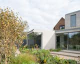 Outdoor, Shrubs, Trees, Large Patio, Porch, Deck, and Garden Part of the house was retained, the thermal fabric was upgraded, and circulation was improved with a more fluid, compact floor plan.  Photos from A Grass-Topped Addition in England Connects Home and Garden