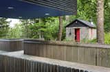 Shed & Studio A restored cinderblock sauna sits across from the main house.  Photo 6 of 15 in Two Rectangular Volumes Unite to Form a Colorful Lakeside Cabin