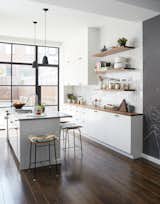 Frederick Tang Architecture renovated this Brooklyn brownstone with entertaining in mind. The new kitchen features a mix of IKEA and custom walnut shelving. The gray subway tile is from Nemo Tile.

