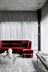 A lavish, velvet-upholstered red sofa in the living room.
