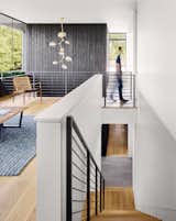 Staircase, Metal Railing, and Wood Tread The large windows open up the interiors by creating double-height spaces that draw natural light into the heart of the house. 

  Photo 8 of 13 in A Glass Addition Unveils Treetop Views For This Texan Home