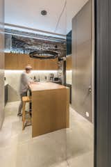 To visually expand the space, the architects created a mirrored threshold between the living lounge and the kitchen/dining area. This, along with a "steklobloky" (a post-industrial, Soviet-style glass wall) that stretches up to the ceiling in the bathroom, work together to bring in plenty of natural light.

  Photo 8 of 16 in Before & After: A Little Flat in Ukraine Gets a Modern Upgrade