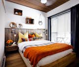 Bedroom, Ceiling, Bed, Night Stands, Wall, and Dark Hardwood An IKEA bed is layered with cozy textiles in the guest bedroom.  Bedroom Bed Wall Dark Hardwood Night Stands Photos from Before & After: An Interior Design Duo Spruce Up Their Canadian Cottage