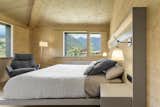 Bedroom, Floor, Chair, Bed, Light Hardwood, Night Stands, Wall, Lamps, and Accent The house has three bedrooms with ensuite bathrooms.  Bedroom Bed Wall Light Hardwood Night Stands Accent Photos from A Winning Residence in the Spanish Pyrenees Mixes Modern and Rustic