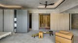 Living Room, Concrete Floor, Stools, and Chair Across from the curved structure is a wall clad in Taiwanese cypress panels.

  Photo 5 of 16 in A Couple Embrace Wabi-Sabi Design to Travel Back to the Past