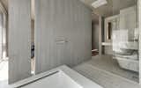 A partition wall separates the master bathroom from the bedroom.