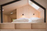 Bedroom, Wall Lighting, Bed, and Storage Under the bed platform is a large wardrobe, storage spaces, and a USB docking station.  Search “munchen-usb-bracelet.html” from A Network of Prefab Tiny Homes Allows Users to "Pay as You Live"