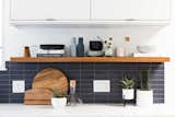 Kitchen, White Cabinet, Subway Tile Backsplashe, and Marble Counter They also added a floating teak shelf from Semihandmade, which was a pretty close match to the Lauan wood paneling in the rest of the house.   Photo 10 of 116 in MX ideas by See Spot Run from Budget Breakdown: A Cramped Eichler Kitchen Gets a $49K Refresh