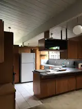 Before: Though floor-to-ceiling windows drew light into the home, the kitchen felt dark due to the mahogany wood panels.   Photo 6 of 9 in Budget Breakdown: A Cramped Eichler Kitchen Gets a $49K Refresh