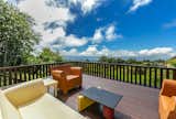 Outdoor, Large Patio, Porch, Deck, Vertical Fences, Wall, Wood Fences, Wall, Grass, Back Yard, Trees, and Wood Patio, Porch, Deck This spacious deck is an ideal setting to soak up the Hawaiian sunshine.

  Search “stoked soak” from A Vibrant, Iconic Home Hits the Market in Hawaii For $9.8M