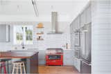 Kitchen, Wall Oven, Refrigerator, Wood, Range Hood, Range, Microwave, Quartzite, Wood, Medium Hardwood, Ceiling, Undermount, and Subway Tile The splash of red repeats itself in the kitchen oven.  Kitchen Wood Medium Hardwood Undermount Subway Tile Photos from Interior Spaces