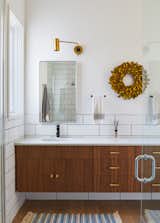 Bath Room, Medium Hardwood Floor, Quartzite Counter, Rug Floor, Subway Tile Wall, Undermount Sink, and Wall Lighting Brass handles and pulls add a touch of luxury to the bathroom.   from Favorites