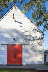 Exterior, Wood Siding Material, Gable RoofLine, House Building Type, Farmhouse Building Type, and Metal Roof Material The exterior door adds a pop of color to the white and gray facade.  Photos from Favorites