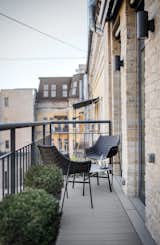 Outdoor, Side Yard, Small, Vertical, Metal, Metal, Wood, Hanging, and Shrubs The living room connects to a small balcony.  Outdoor Hanging Metal Vertical Side Yard Photos from A Monochromatic Palette Unifies Old and New in This Ukrainian Bachelor Pad
