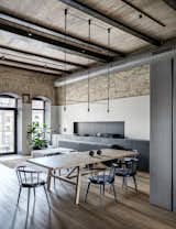 Dining Room, Track Lighting, Pendant Lighting, Table, Chair, Rug Floor, Medium Hardwood Floor, and Storage Frattino table by Miniforms.  Photos from A Monochromatic Palette Unifies Old and New in This Ukrainian Bachelor Pad