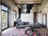 Living Room, Medium Hardwood Floor, Track Lighting, Sofa, Coffee Tables, Rug Floor, and Storage  Photos from A Monochromatic Palette Unifies Old and New in This Ukrainian Bachelor Pad