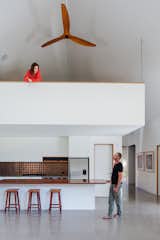 Kitchen, Concrete, Refrigerator, White, Cooktops, Metal, Wood, Recessed, Range, and Range Hood Fans were added for improved air circulation.  Kitchen Recessed White Concrete Range Hood Photos from Two Barn-Like Volumes Make Up This Low-Maintenance Australian Home