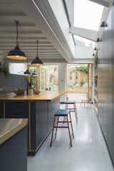 Kitchen, Wood, Concrete, Wood, Pendant, and Ceiling Skylights dramatically brighten the kitchen.

  Kitchen Ceiling Wood Pendant Concrete Photos from Before & After: A London Home Doubles as a Cheery Work Space