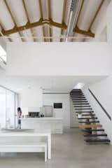 Floating stairs in the dining area lead up to a mezzanine loft.