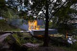 Exterior, Concrete Siding Material, Flat RoofLine, House Building Type, and Wood Siding Material A section of the concrete volume cantilevers above the brook that connects the two ponds.  Photo 6 of 15 in Two Ponds Bookend This Concrete-and-Wood Residence in Portugal