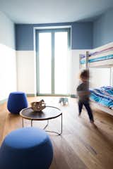 Kids, Bunks, Bedroom, Medium Hardwood, Toddler, Neutral, Chair, and Night Stands The children's bedroom with bunk beds.  Kids Bunks Toddler Medium Hardwood Bedroom Photos from A Renovated Apartment in an 18th-Century Sicilian Building Pays Homage to the Sea