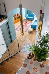 Architecture and design studio LYGA used an intense blue-green paint for the arched threshold in the main living area to create chromatic richness and a romantic mood.