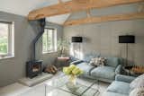 Living Room, Wood Burning Fireplace, Floor Lighting, Coffee Tables, End Tables, Rug Floor, Sofa, and Concrete Floor A living lounge with a wood-burning fireplace.  Photos from A Beautifully Renovated Barn House Reveals Rustic Roots in South East England