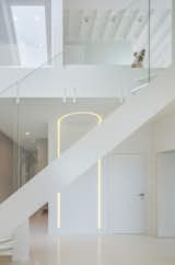 A modern white staircase connects the two levels.