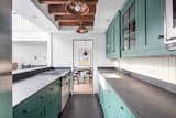 The kitchen features cheerful, sea-green cabinetry.


