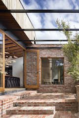 A steel pergola creates an outdoor living space; in the summer, grape vines climb up to create a lush canopy.
