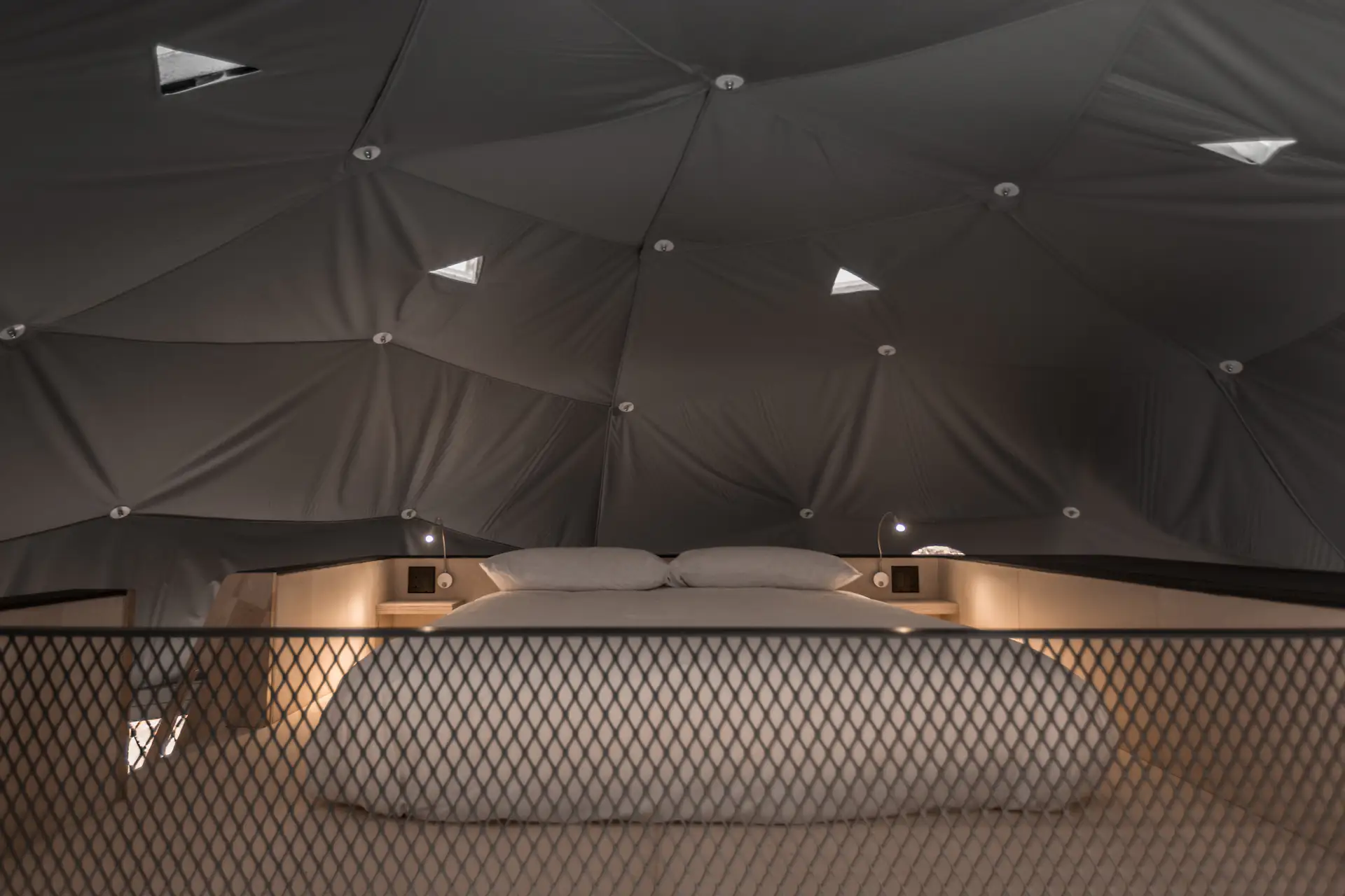 The second bed is located above the black volume. Triangular skylights allow guests to glimpse the outdoors.